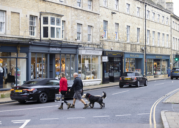 Shoppers and independent stores along Stamford's historic High Street limestone buildings