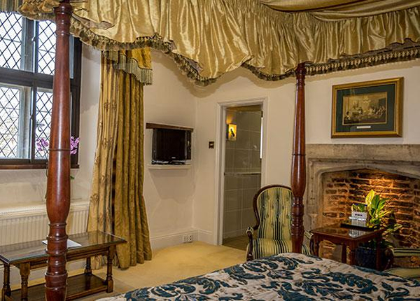 A characterful four-poster bedroom with an inglenook fireplace in Stamford accommodation